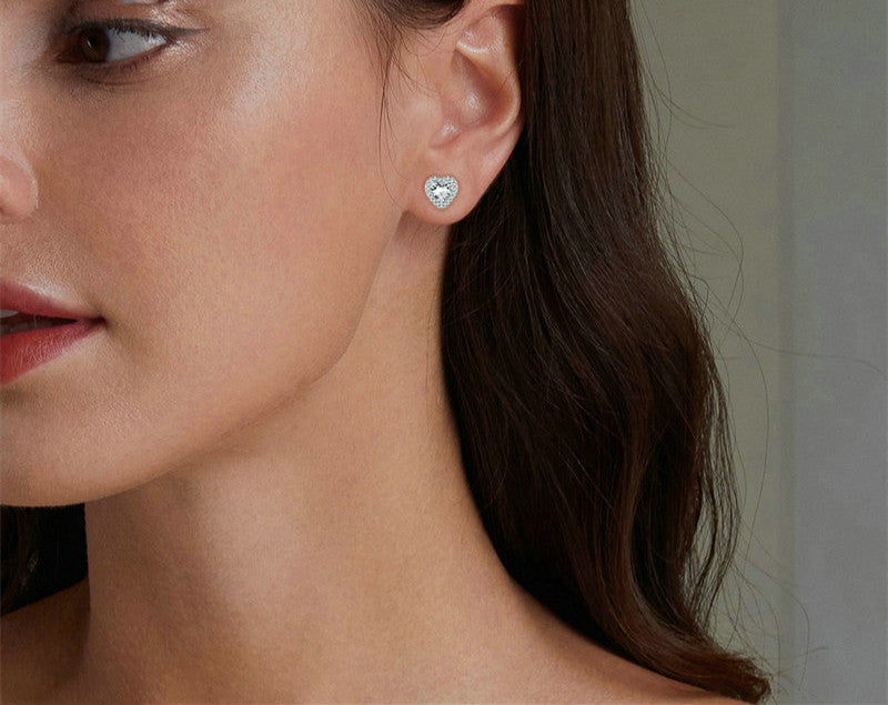 Photo of a woman wearing sterling silver heart stud earrings with zircon