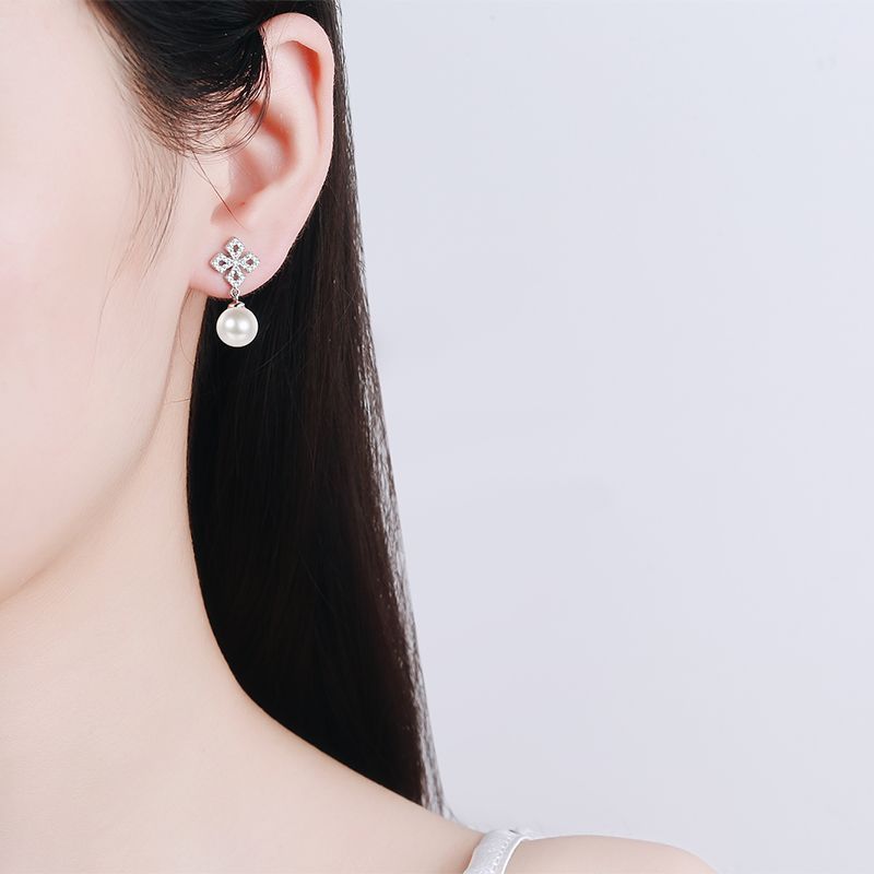 Photo of a woman wearing silver moissanite earrings with freshwater pearl